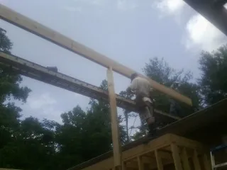 Carpenter setting a ridge beam over a new addition frame — Ice Dam Removal by Roofing Brothers in Oberlin