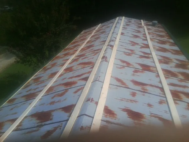 Rusted metal roof panels with new wood purlins before replacement — Storm Damage Roof Repair in Oberlin by Roofing Brothers