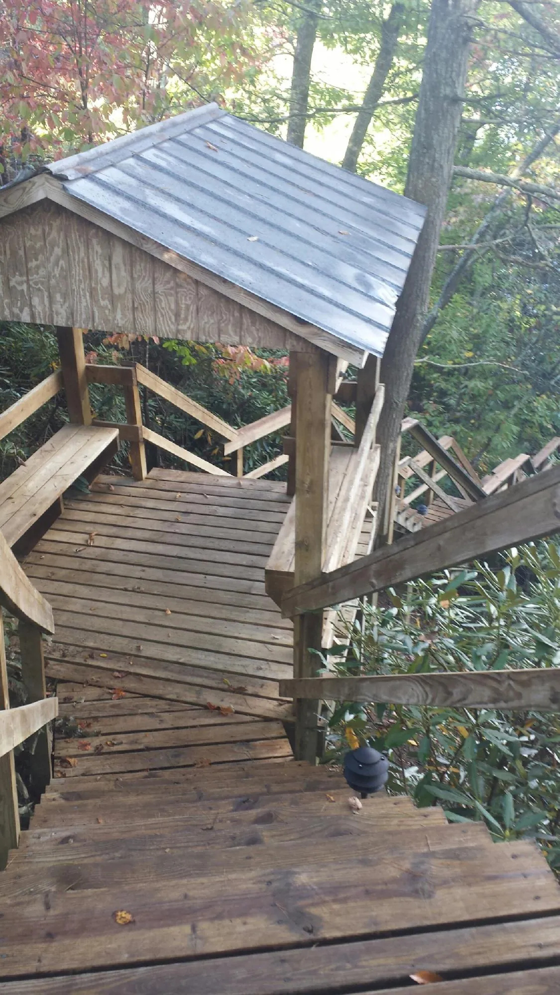 Metal roofed shelter over wooden steps on a wooded walkway — Skylight Repair & Installation work by our crew in Oberlin