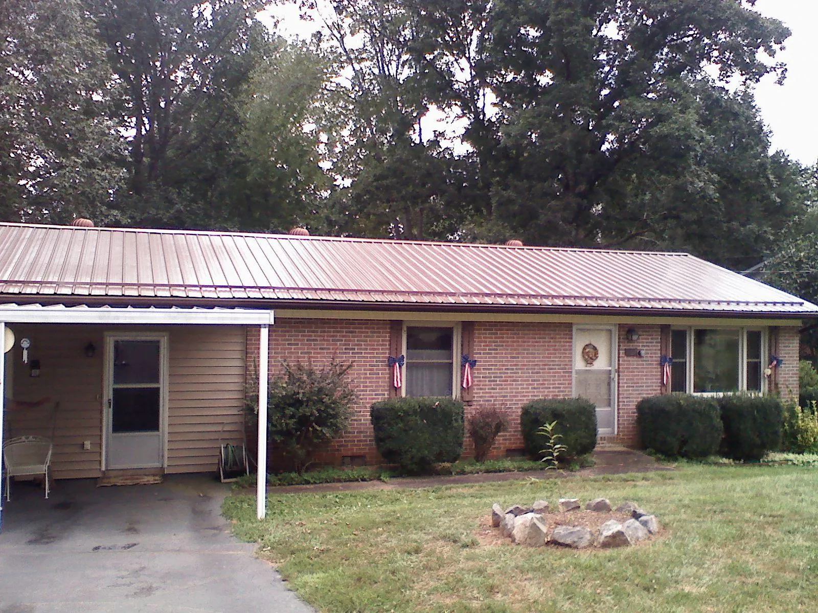 Bronze metal roof and carport on a brick ranch home — Roof Repair work by our crew in Oberlin